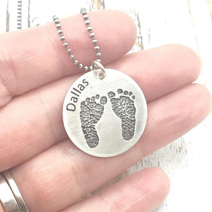 Etched foot print necklace in hand