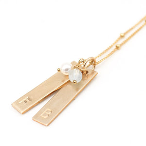 handstamped gold bar necklace with gemstones.