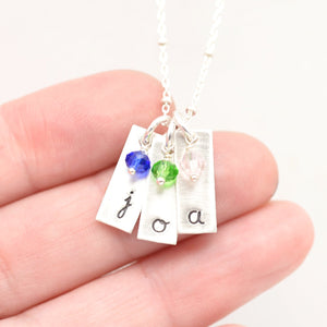 handstamped bar pendants with gemstones in hand