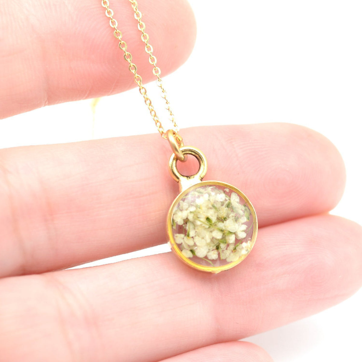 Dainty blossoms gold necklace in hand